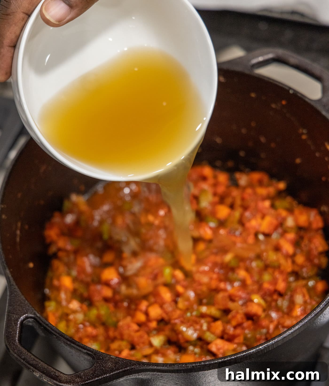 Meltingly Tender Veal Osso Buco 11 pouring chicken broth into veal osso buco