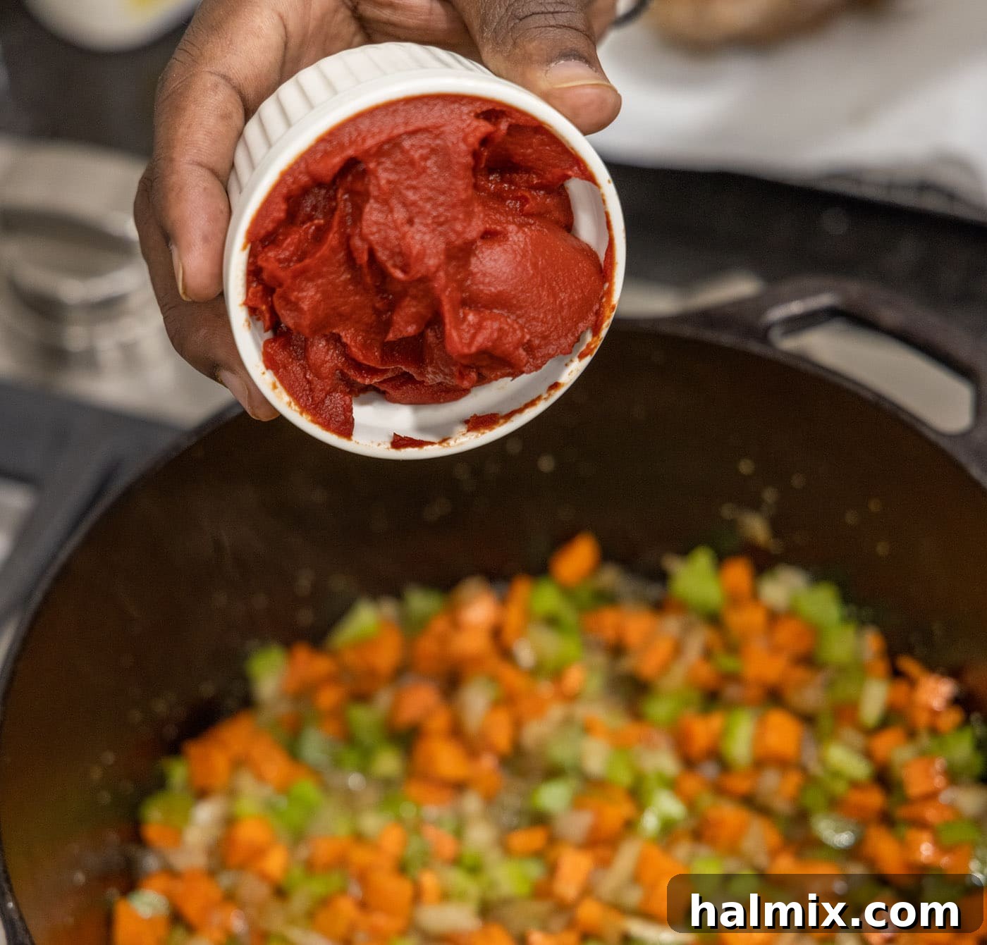 Meltingly Tender Veal Osso Buco 10 adding tomato paste to celery, onion, and carrots in a dutch oven