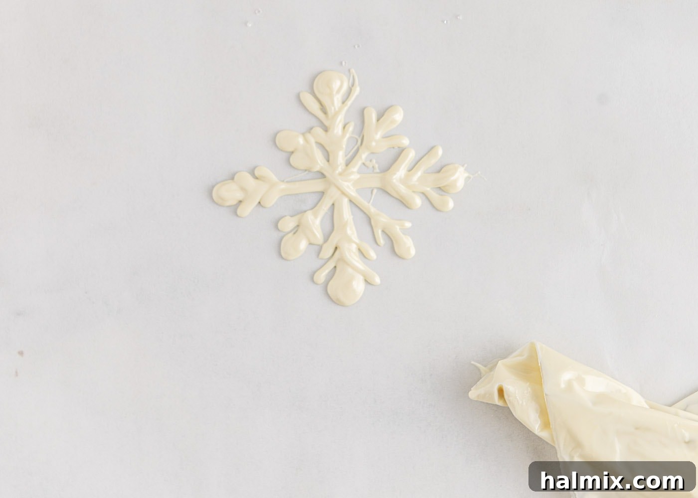 Another step showing the creation of white chocolate snowflakes