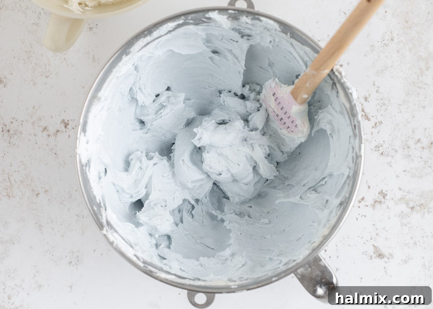 Baby blue buttercream frosting in a mixing bowl