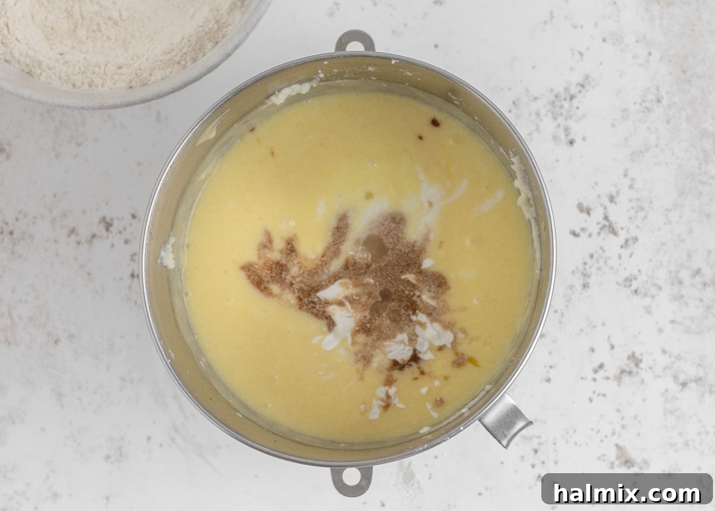 Sour cream and vanilla being added to the cake batter