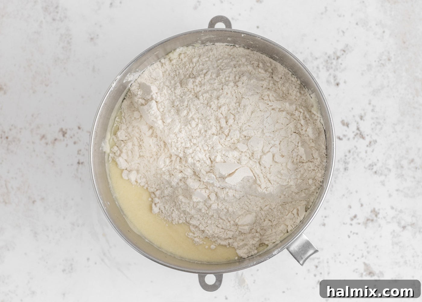 Flour mixture being added to the wet cake batter ingredients