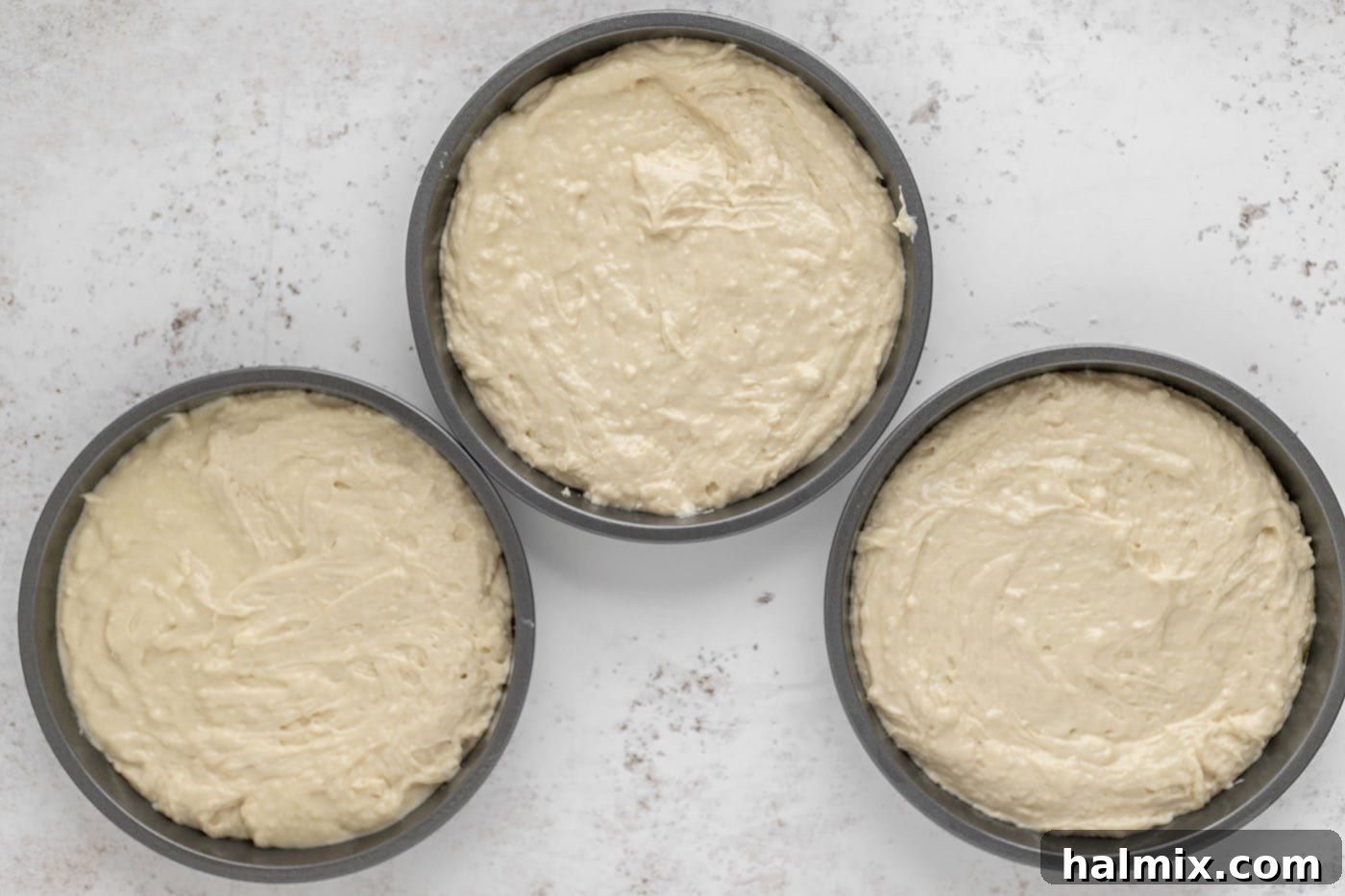 Cake batter evenly divided in baking pans