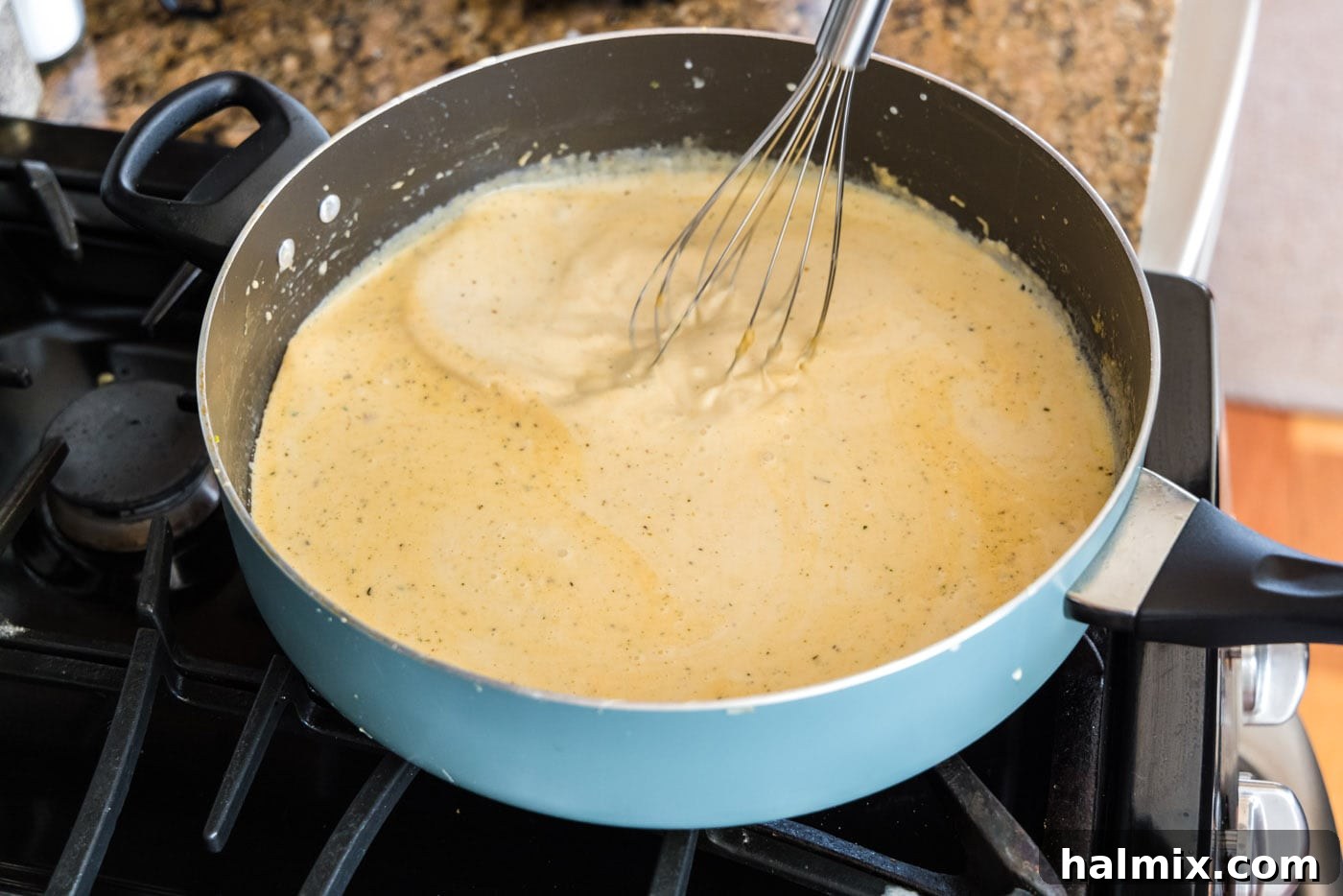 Fisherman's Lasagna 14 Whisking the creamy sauce in a saucepan until it is smooth and slightly thickened, with no lumps.
