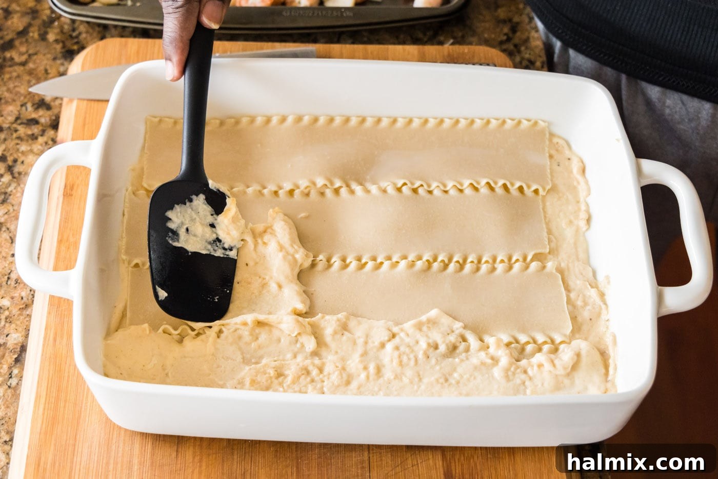 Fisherman's Lasagna 17 Spreading a layer of rich cream sauce over the lasagna noodles.