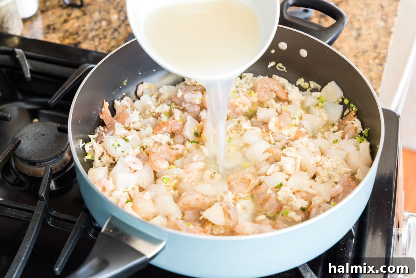 Fisherman's Lasagna 7 Pouring stock into the skillet containing seafood, garlic, and green onions for the seafood lasagna.