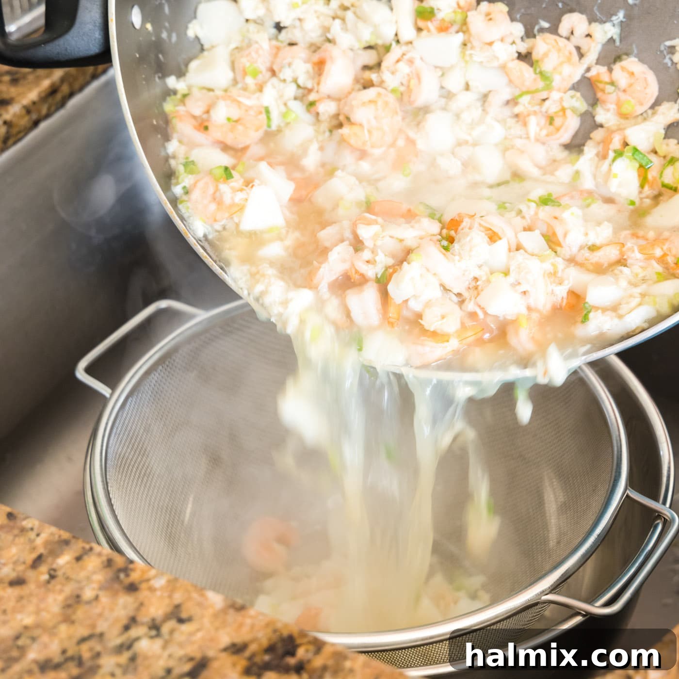 Fisherman's Lasagna 8 Draining the cooked seafood mixture through a colander into a bowl, reserving the flavorful broth.