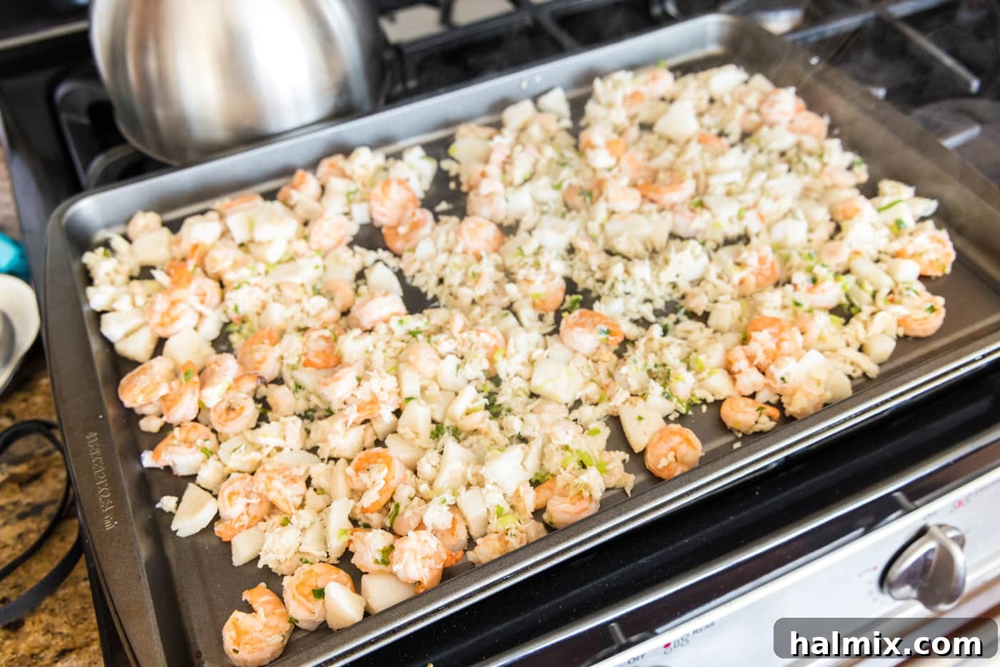 Fisherman's Lasagna 9 Cooked crab meat, scallops, and shrimp cooling on a baking tray.