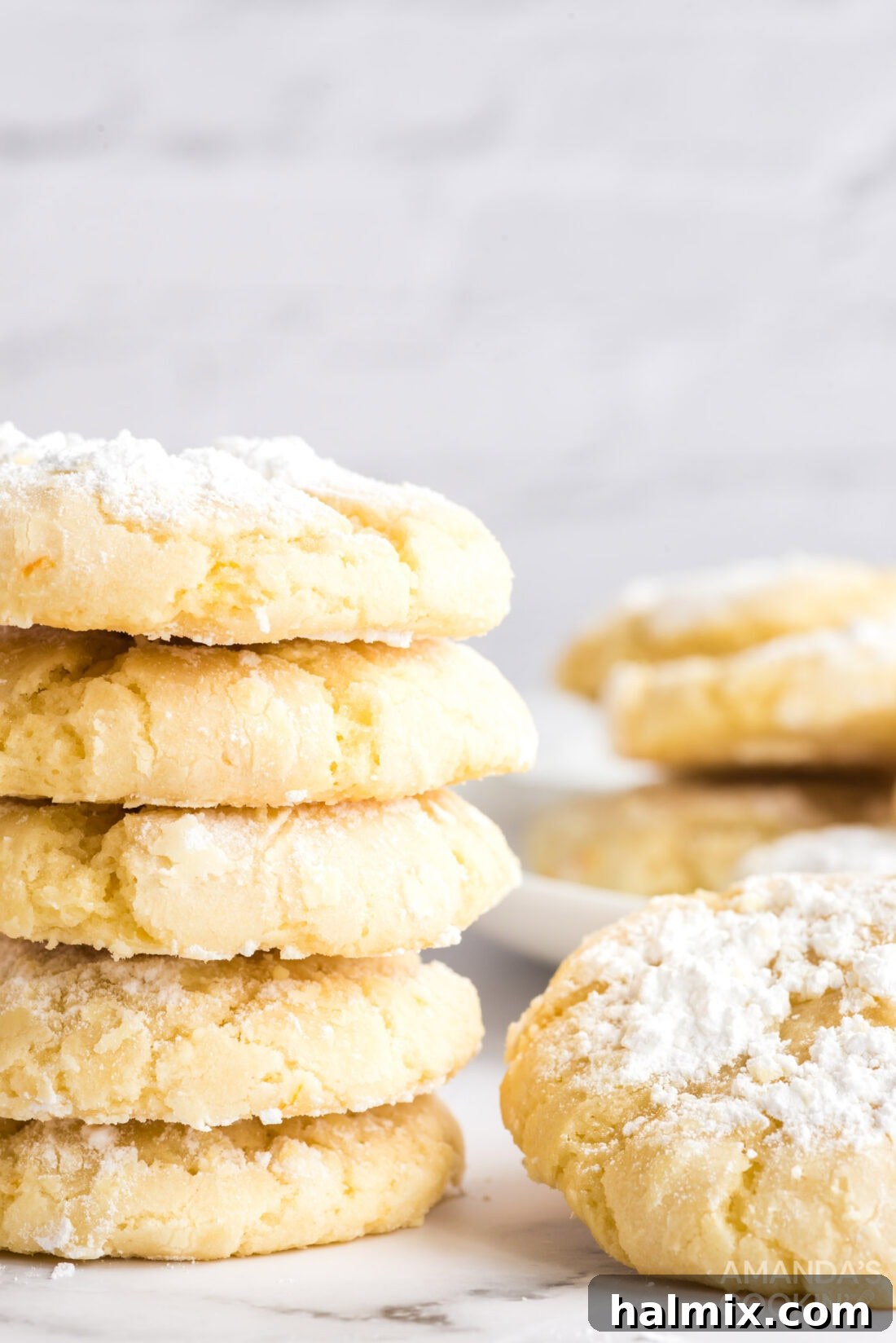 Orange Crinkle Cookies are soft, chewy, and bursting with real orange flavor from juice and zest. Roll the dough in powdered sugar and bake for a perfect crinkled texture. Another view of vibrant orange crinkle cookies artfully arranged on a serving plate, highlighting their appealing texture and festive dusting of powdered sugar.