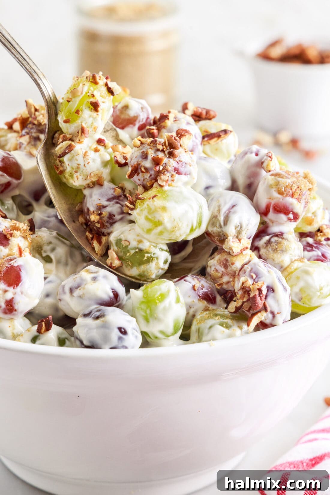 spoon lifting Grape Salad from a serving bowl
