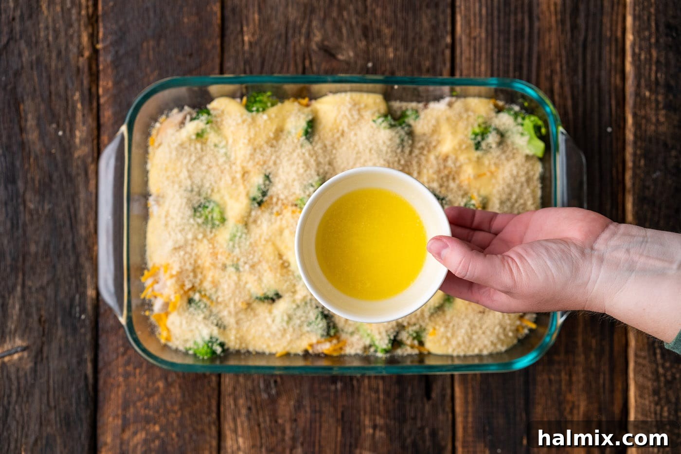 Melted butter being drizzled over the panko breadcrumbs, ready for baking.