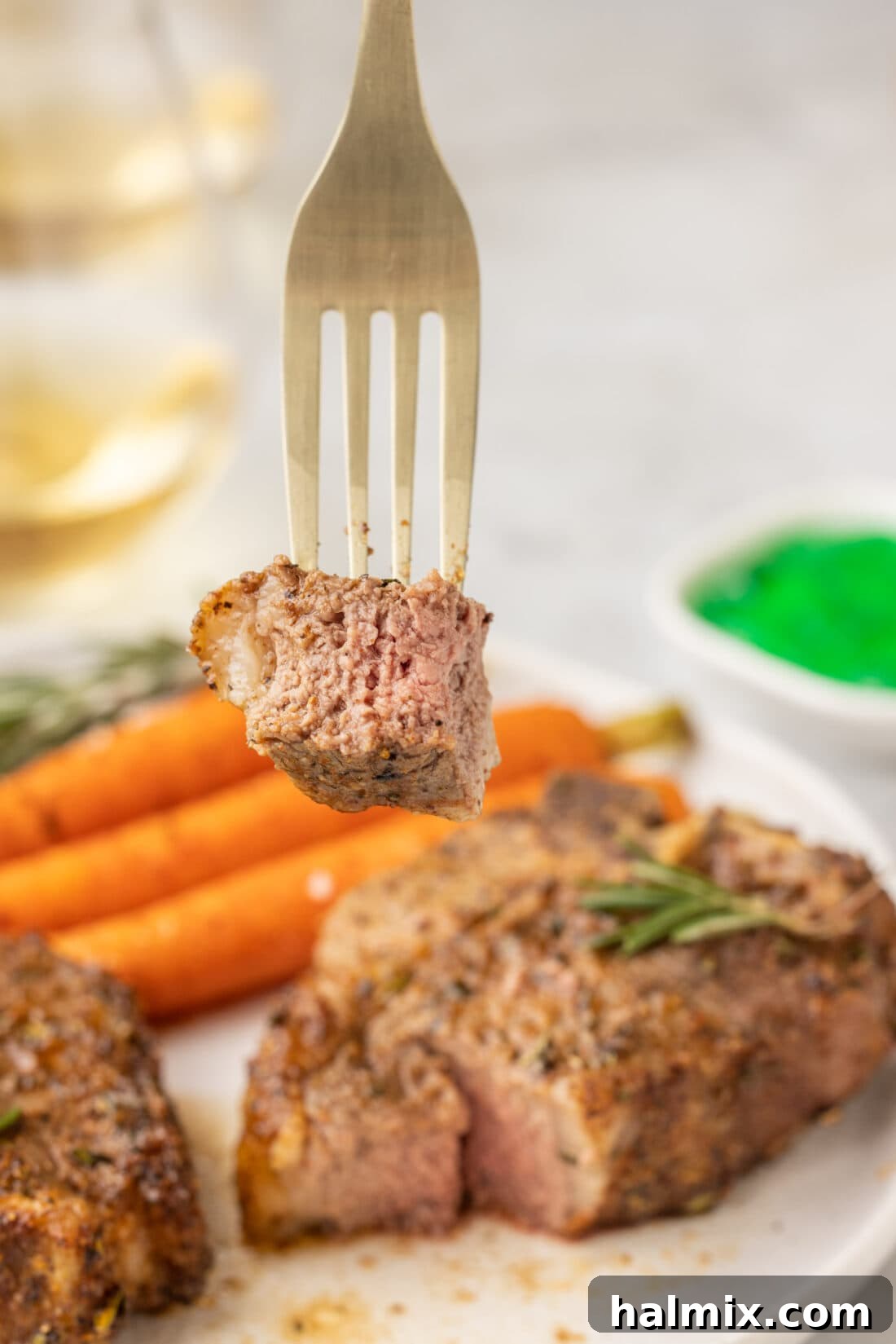 A fork holding a perfectly cooked, juicy air fryer lamb chop