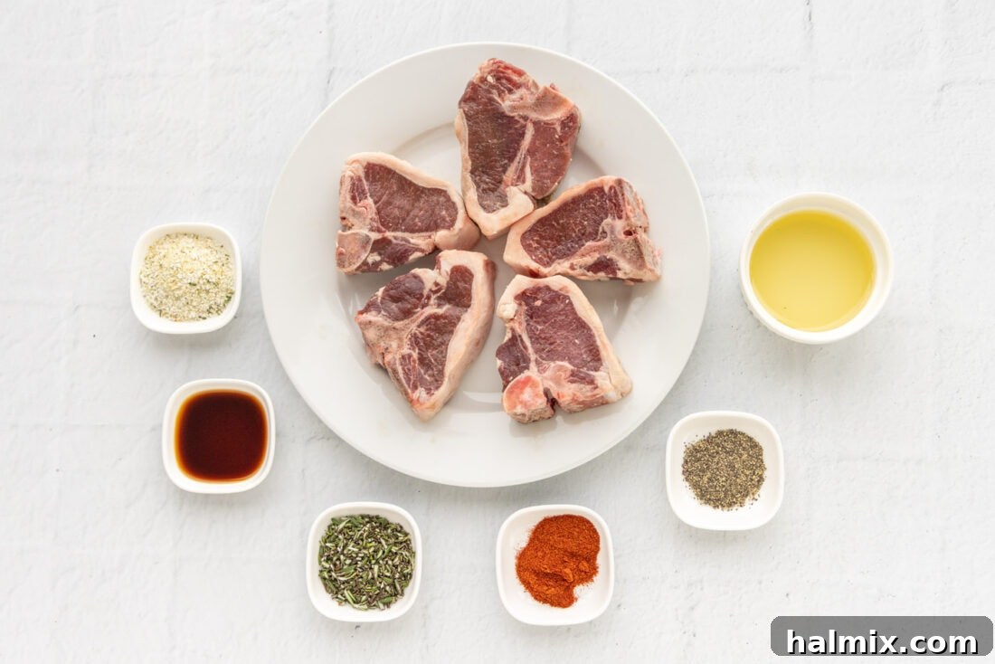 A collection of fresh ingredients laid out for Air Fryer Lamb Chops, including lamb, rosemary, garlic, and spices