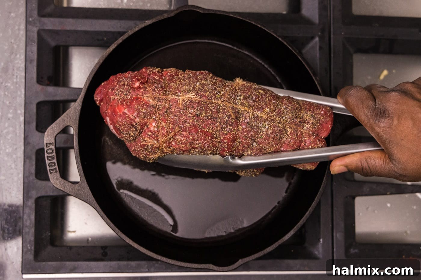 searing beef tenderloin in a hot skillet with olive oil