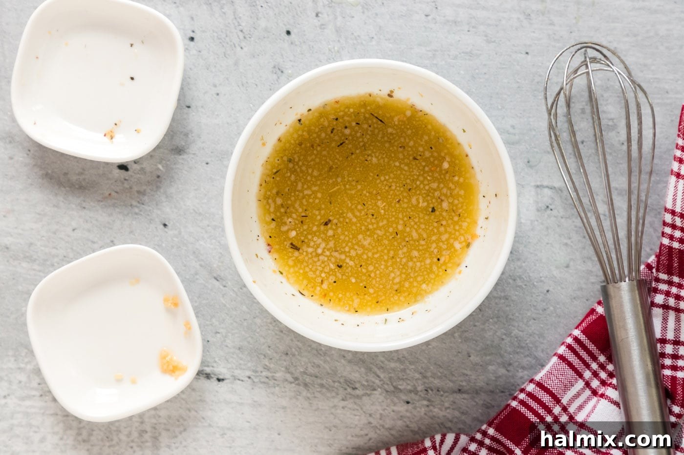 small bowl containing melted butter, roasted garlic seasoning, and minced garlic