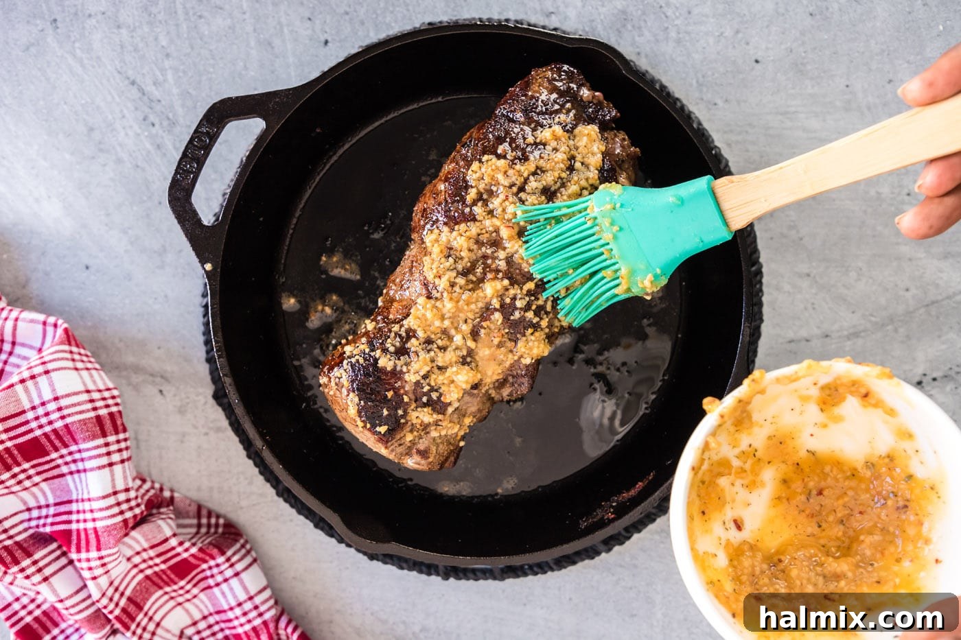brushing the melted butter and garlic mixture over the seared beef tenderloin