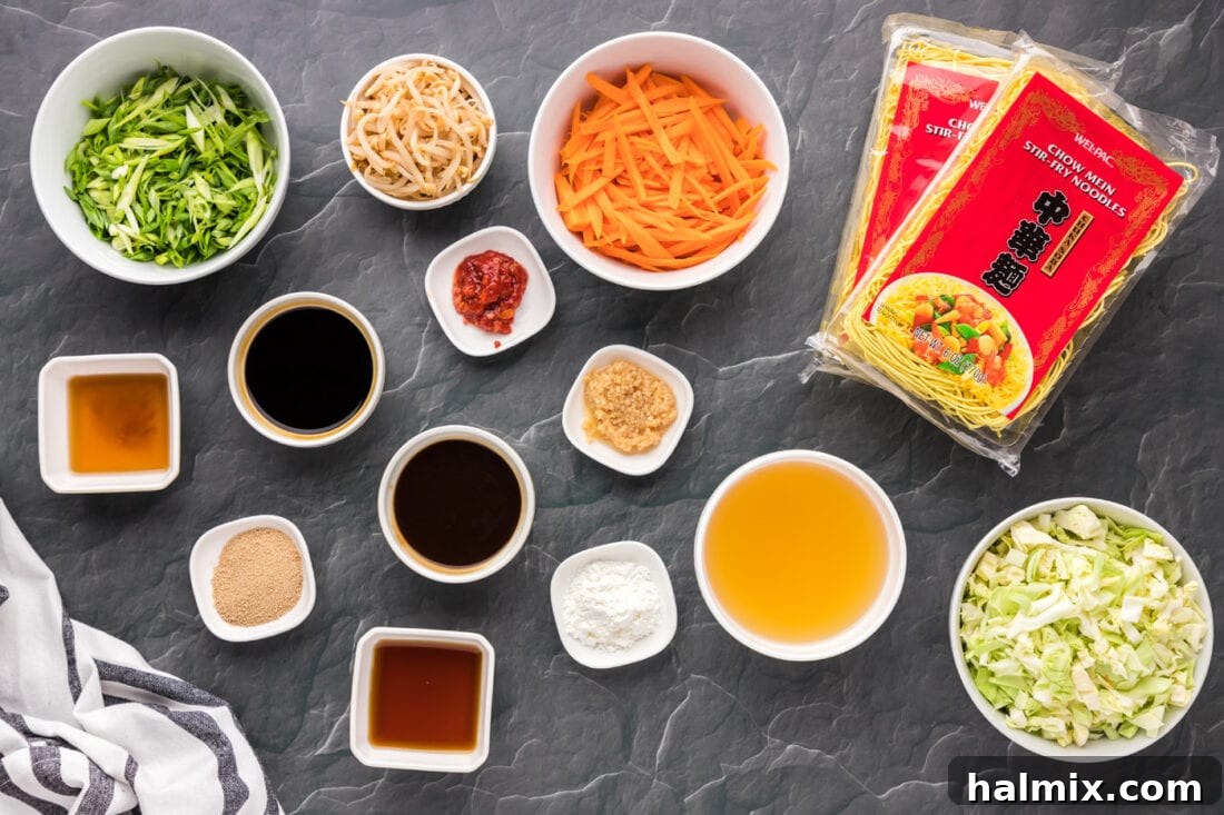 Arrangement of fresh ingredients including noodles, vegetables, and sauces for making Chow Mein.