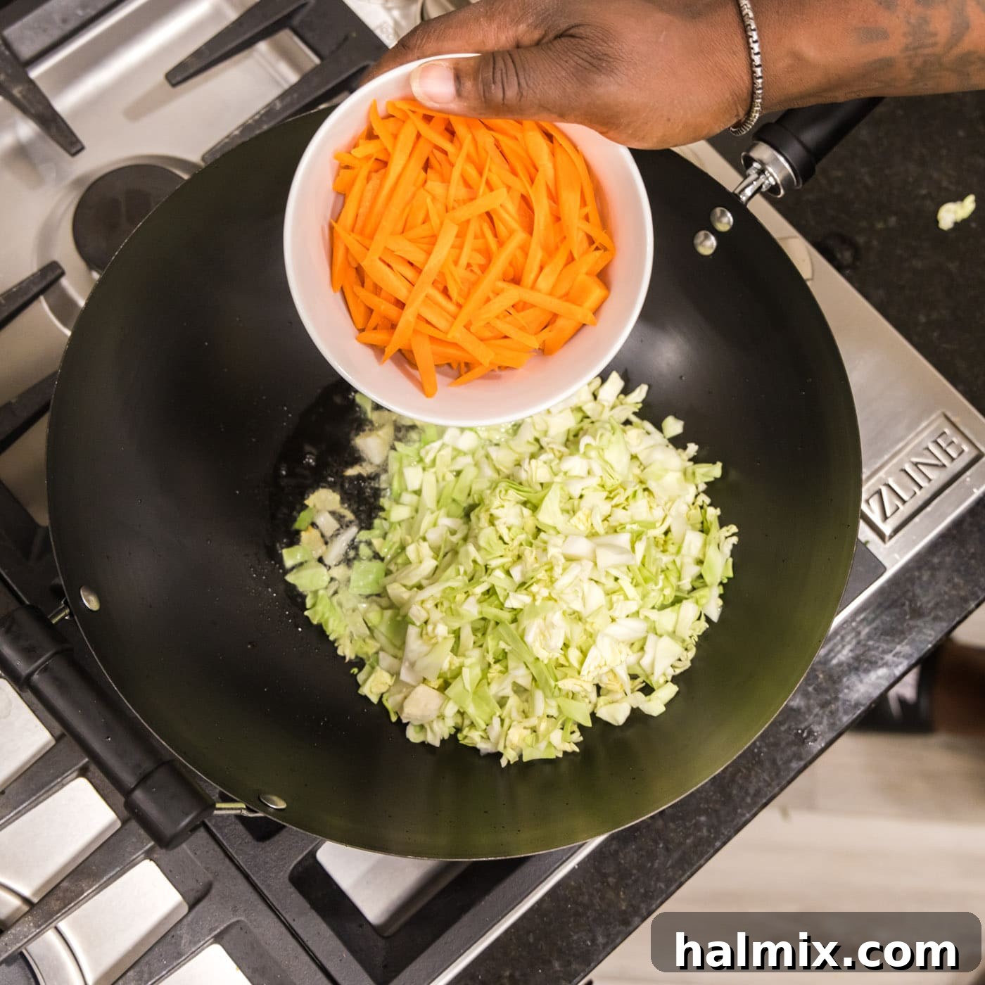 Adding carrots with cabbage to a wok