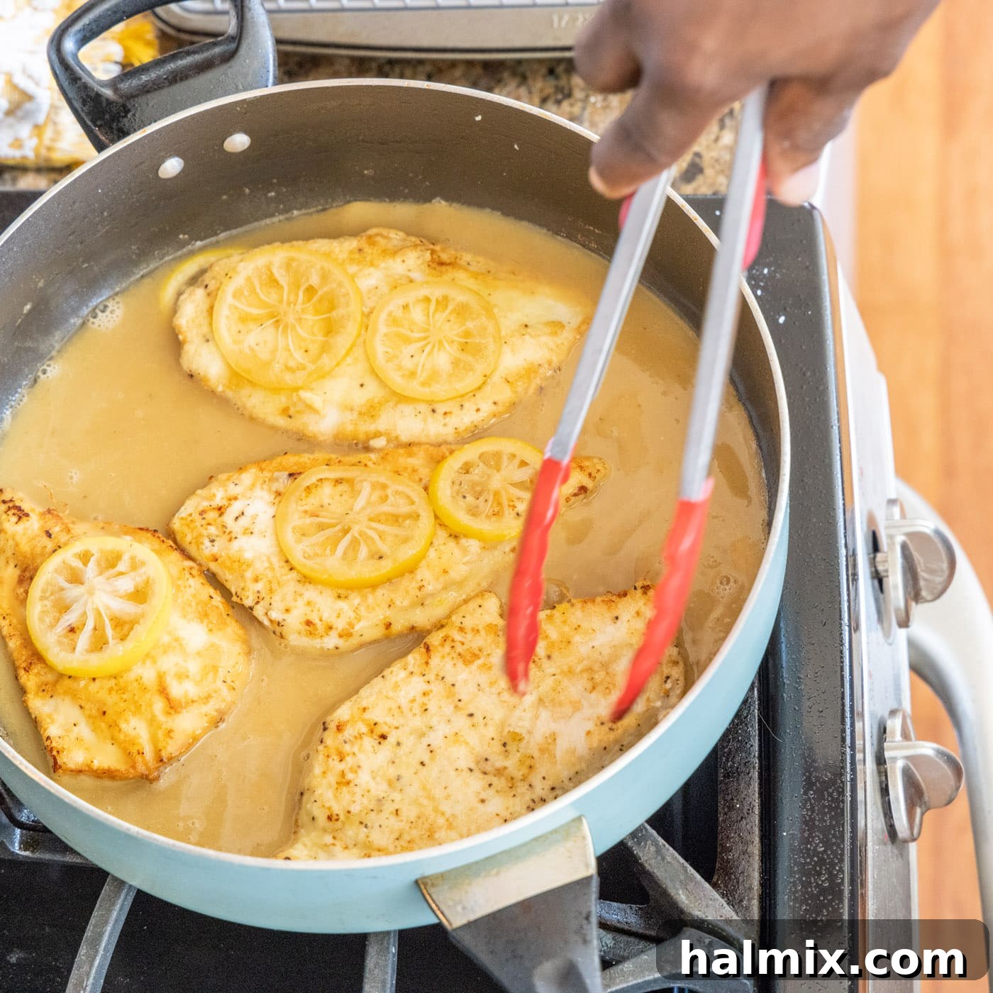 Chicken Simmering in Francese Sauce Cooked Chicken Francese returning to the skillet to simmer in the sauce