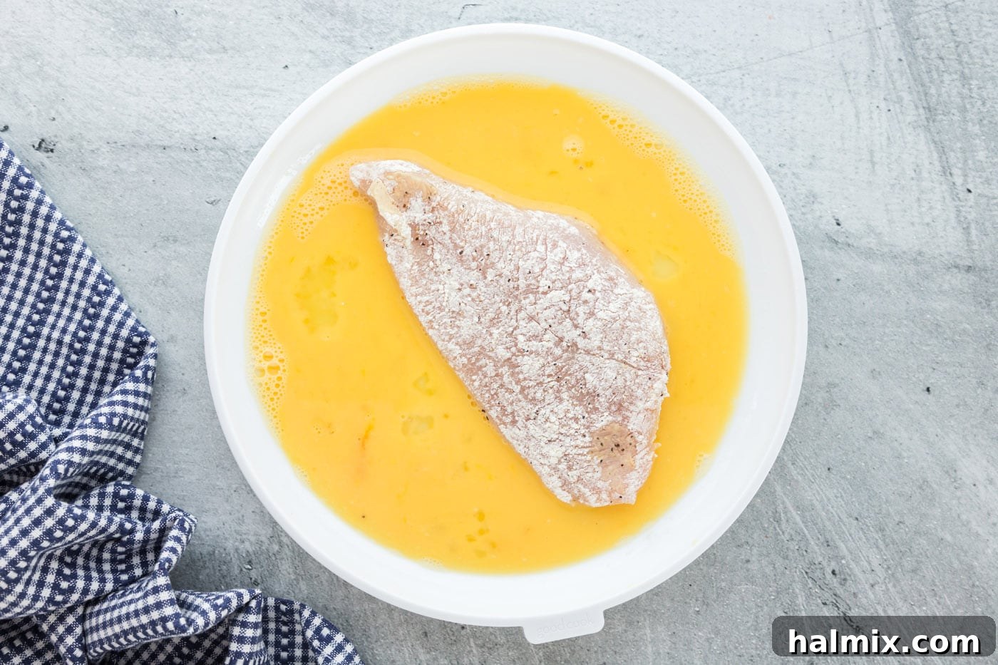 Chicken Ready for Egg Wash Four floured chicken breasts ready to be dipped into the egg mixture