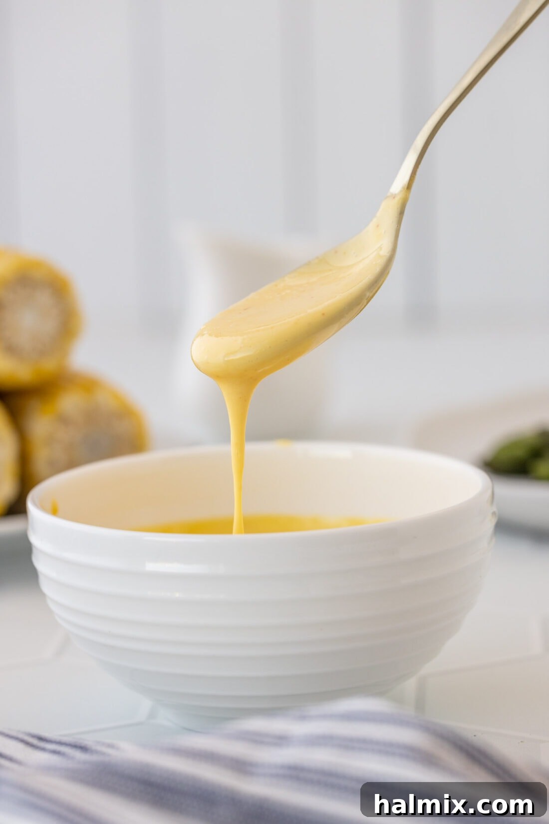 Velvety Hollandaise Sauce 2 spoon drizzling Hollandaise Sauce