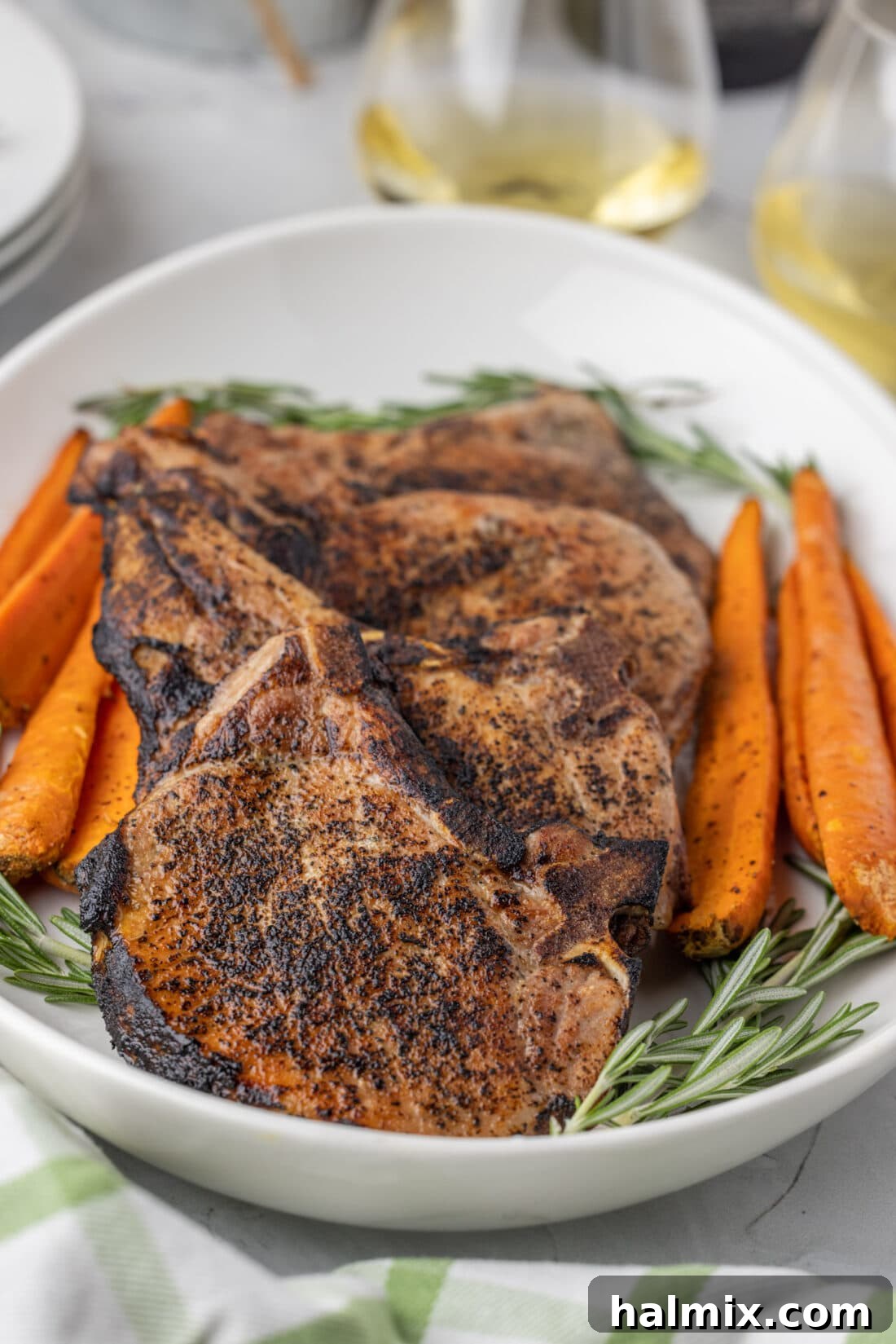 Platter of perfectly cooked Sous Vide Pork Chops, golden brown and garnished with herbs.