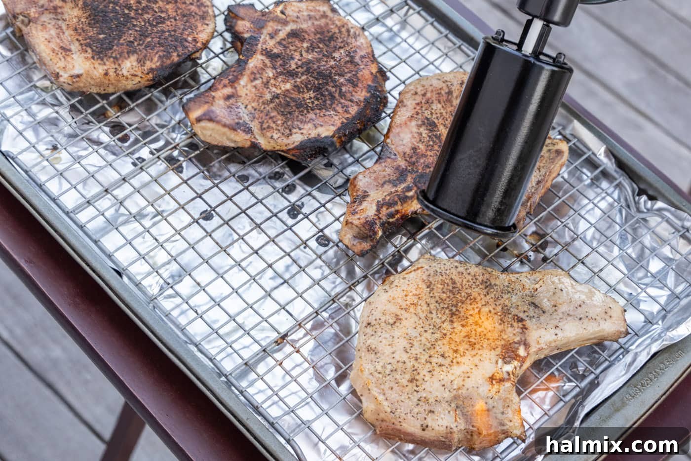 Another perspective of a kitchen torch creating a perfect sear on sous vide pork chops, enhancing their visual appeal.