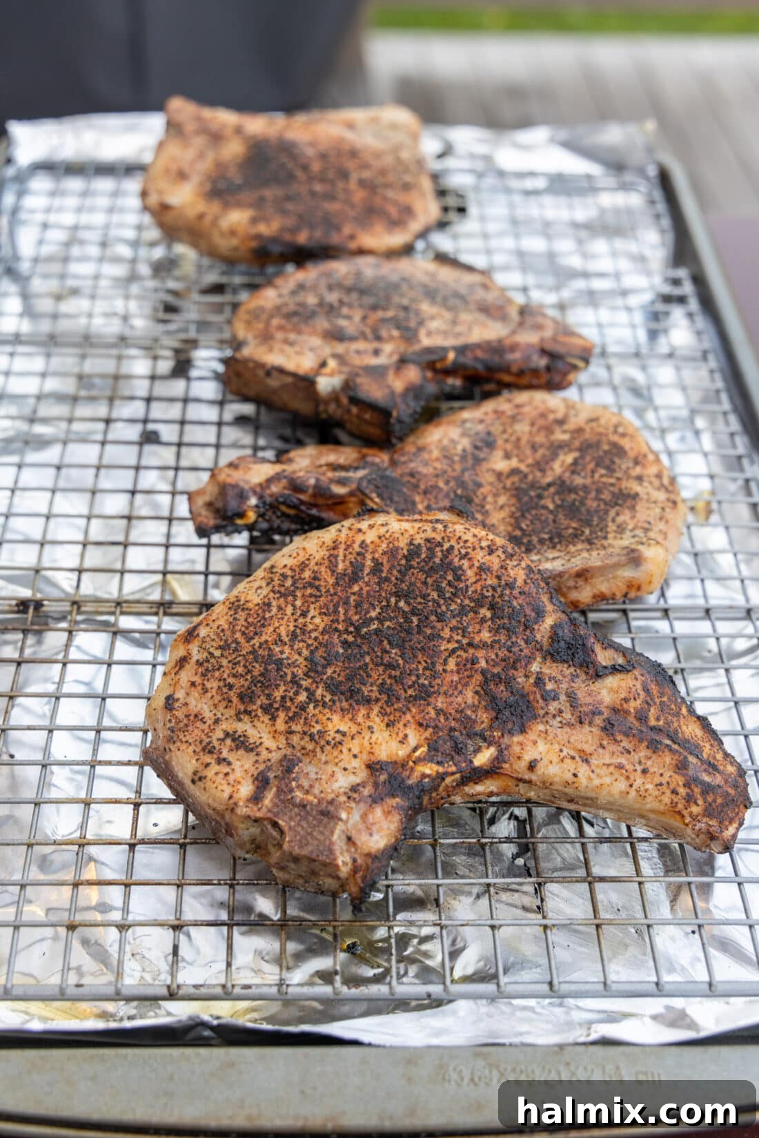Sous Vide Pork Chops resting on a wire rack after cooking, ready for searing to achieve a golden crust.