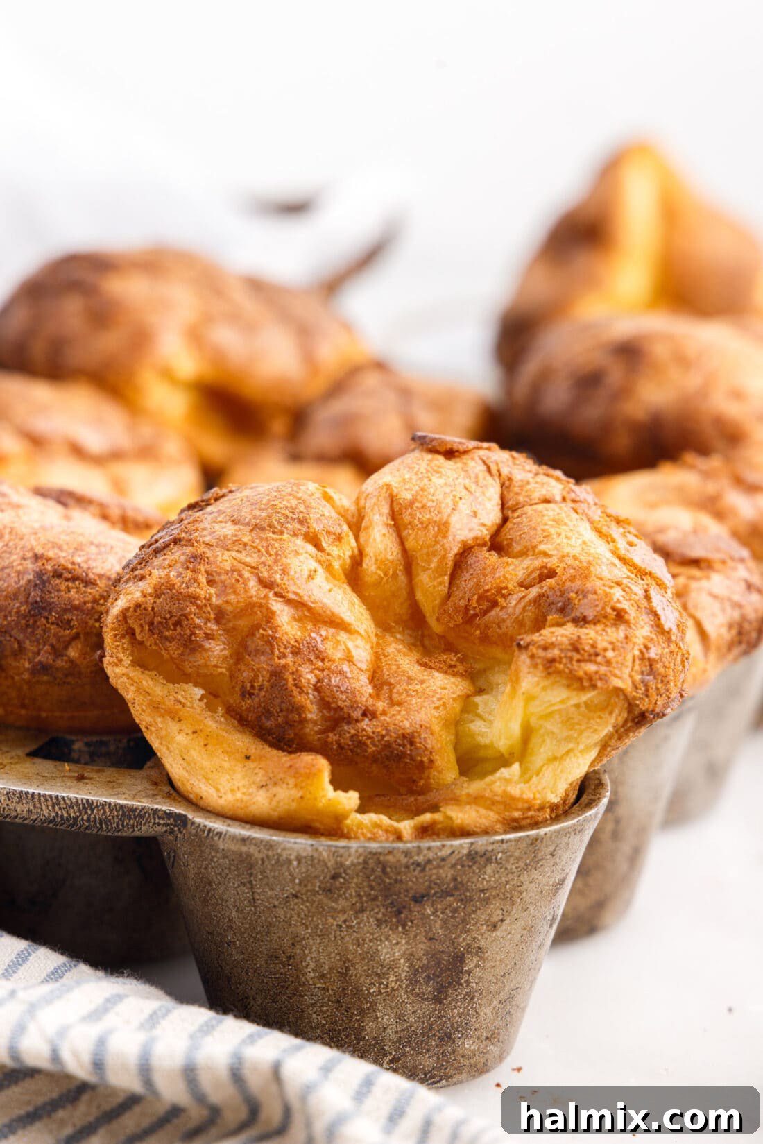 Golden Popovers 2 Freshly baked popovers in a specialized popover pan, showcasing their tall, golden-brown peaks and perfect rise.