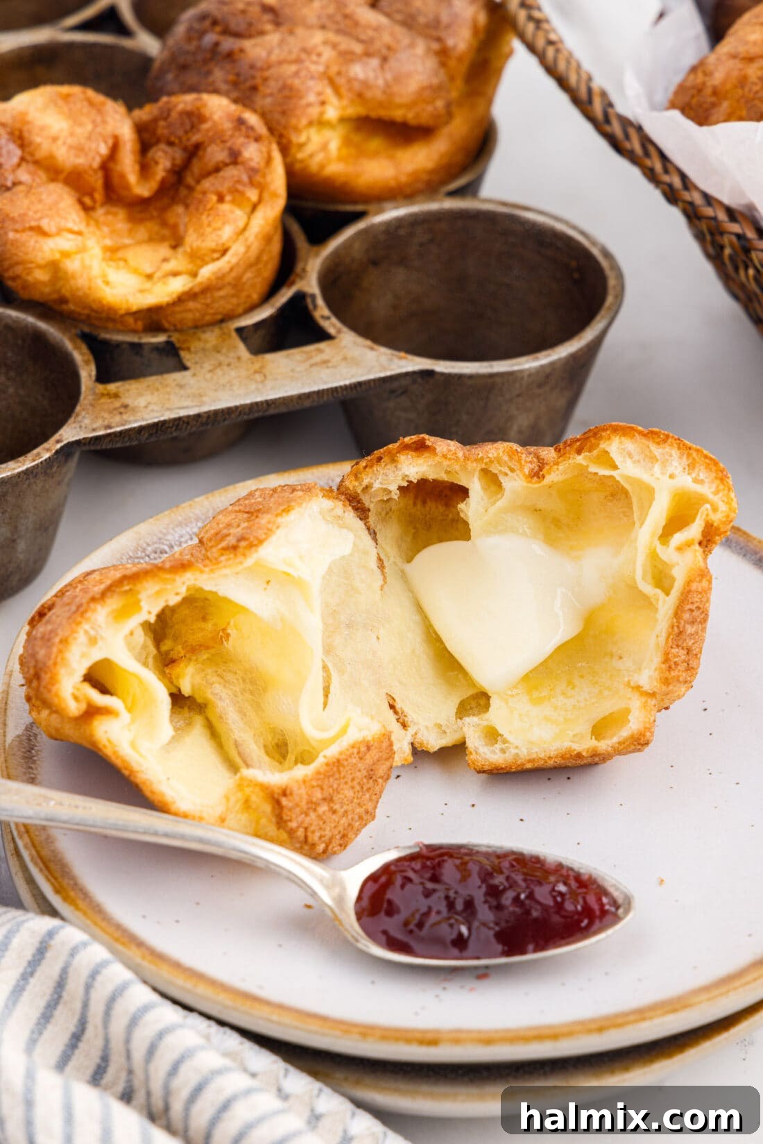 Golden Popovers 11 A perfectly golden popover, split open and generously smeared with soft butter and a dollop of vibrant jam.