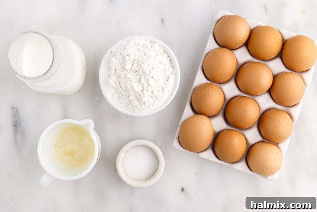 Golden Popovers 4 A collection of popover ingredients, including eggs, milk, flour, butter, and salt, neatly arranged on a kitchen counter.