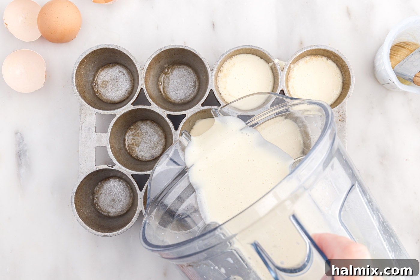 Golden Popovers 9 Pouring the smooth popover batter into individual cups of a preheated popover tin.