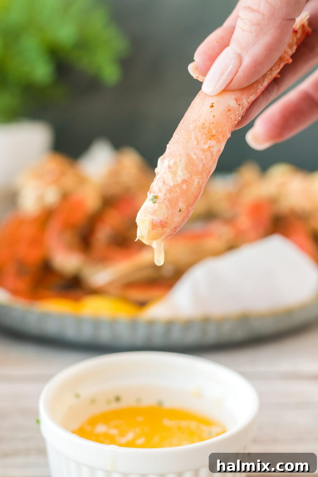 dipping a piece of crab leg into butter