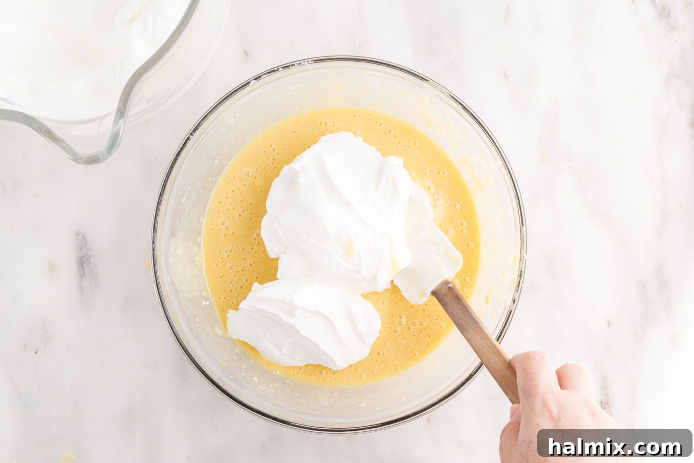 Folding egg whites into the main cake batter with a rubber spatula