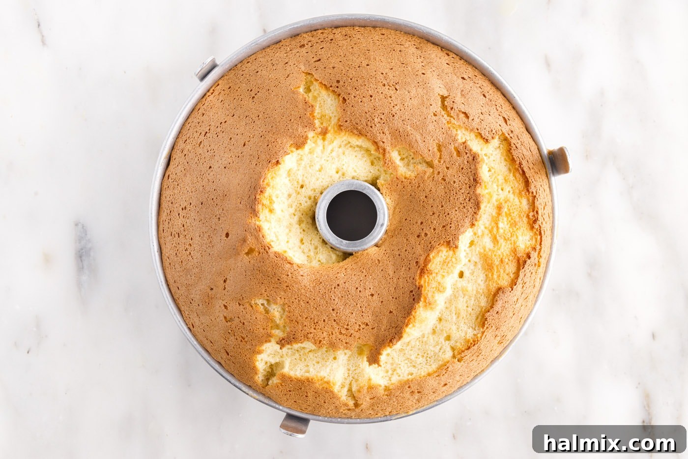Freshly baked chiffon cake cooling in its tube pan