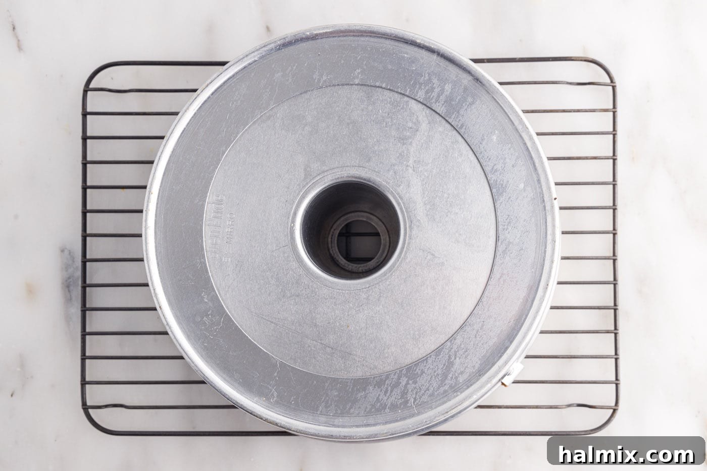 Tube pan inverted upside down for cooling chiffon cake, a crucial step
