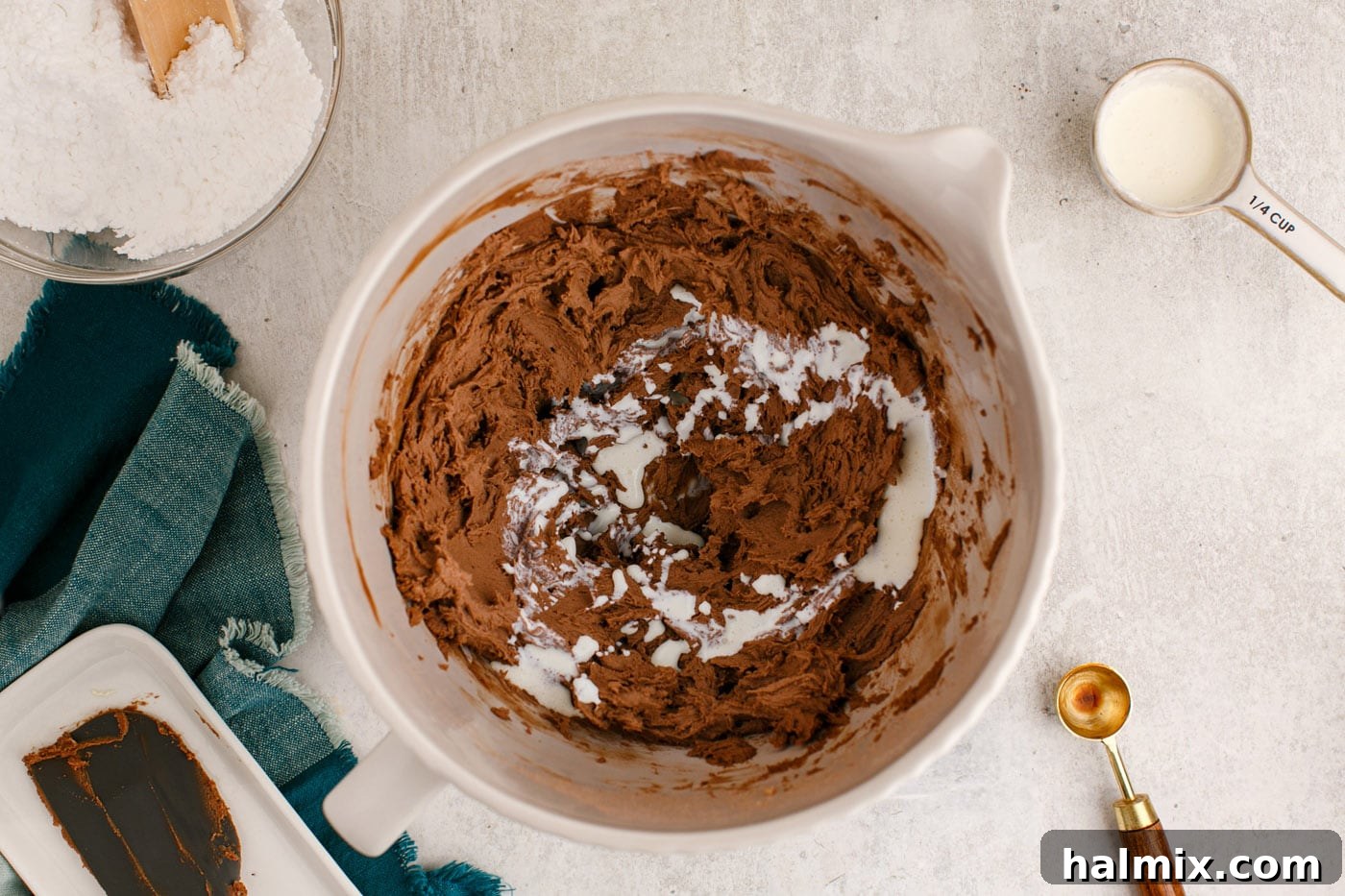 adding the final touches of heavy cream to the chocolate buttercream frosting in a stand mixer