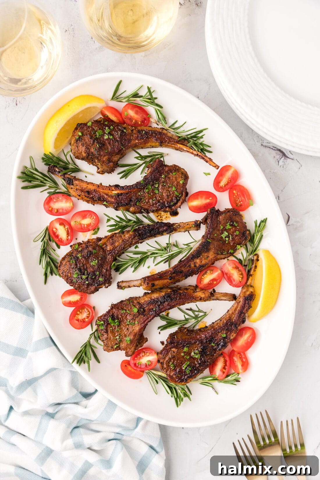 Close-up of baked lamb chops on a white platter, perfectly cooked