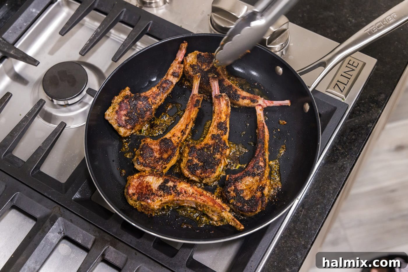 Flipping lamb chops in a skillet during searing