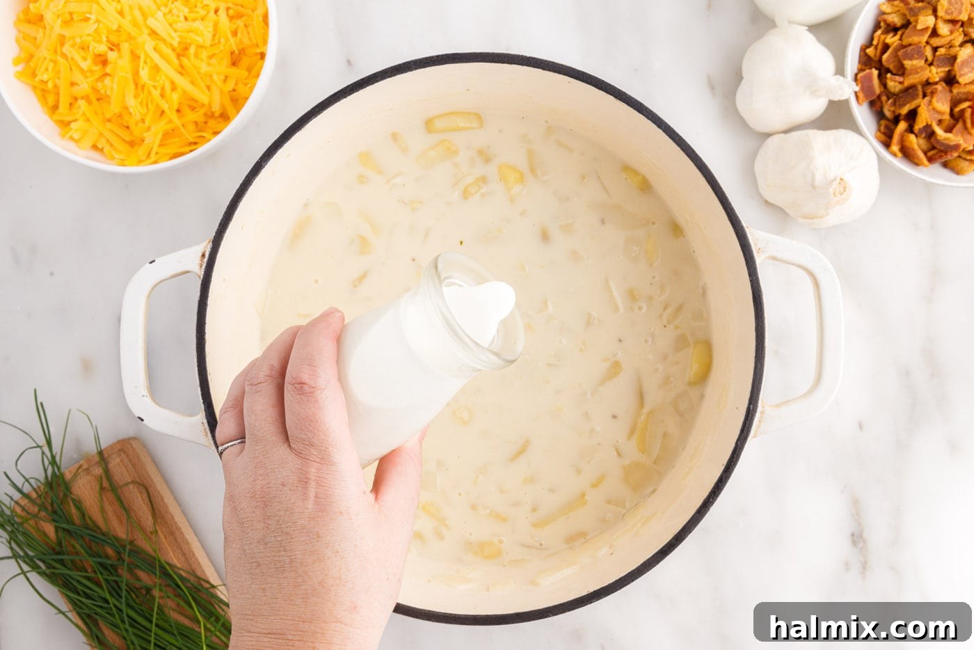 Hearty Loaded Baked Potato Soup 11 Pouring heavy cream into the simmering baked potato soup for extra richness and creaminess.