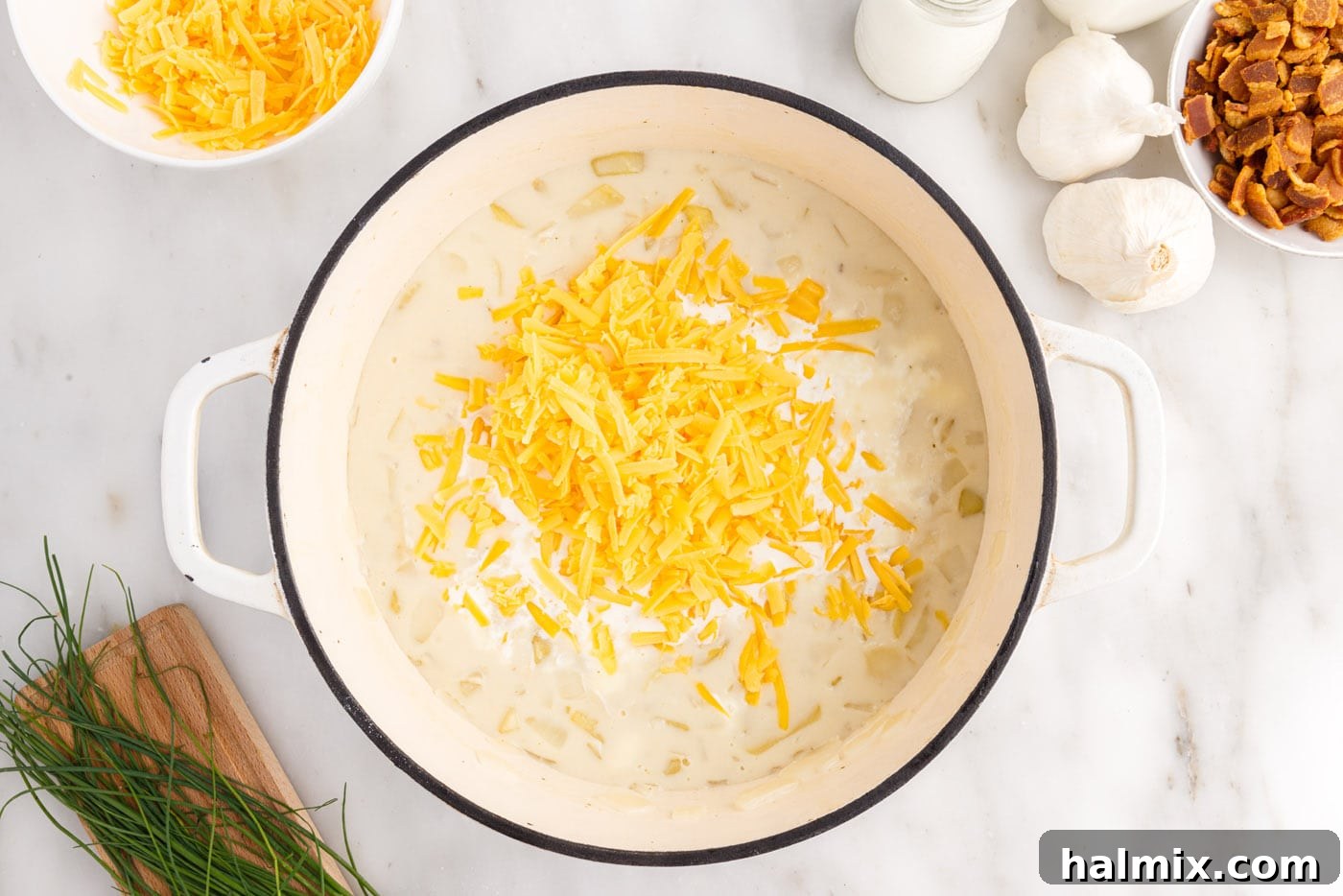 Hearty Loaded Baked Potato Soup 12 Adding shredded cheddar cheese to the baked potato soup, stirring until melted and smooth.