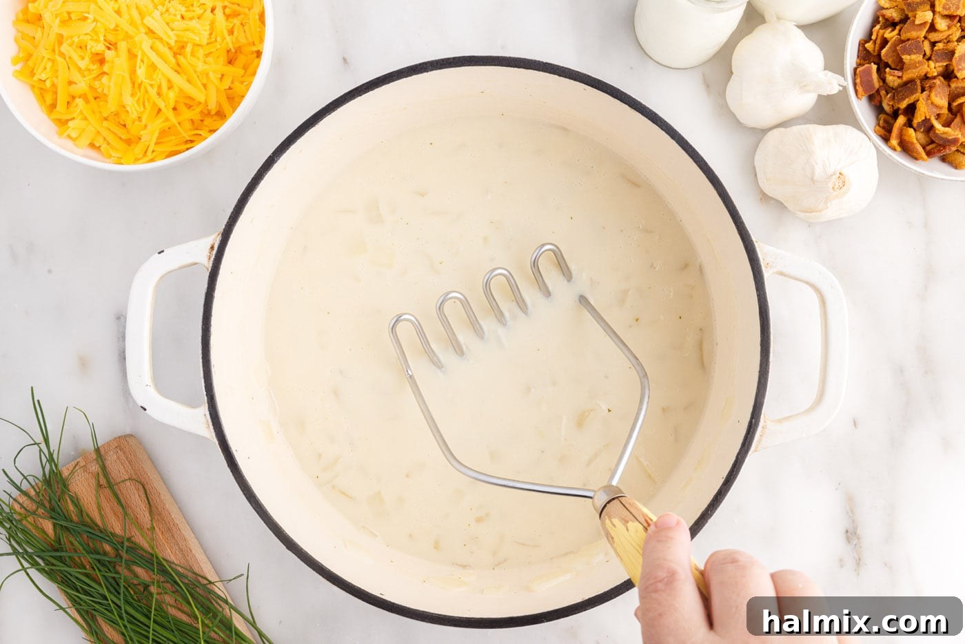 Hearty Loaded Baked Potato Soup 10 Using a potato masher to break up chunks of potato in the simmering soup, adjusting consistency.