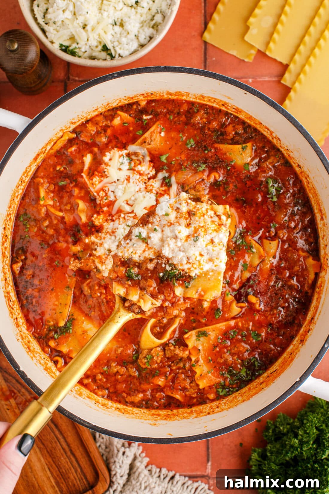 Spoonful of Lasagna Soup over pot of Lasagna Soup, highlighting tender noodles, meat, and broth