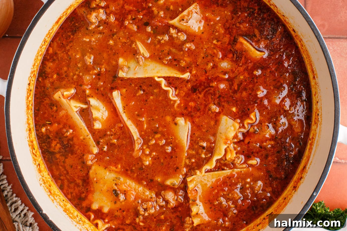 Lasagna soup simmering without a lid, with noodles fully cooked and integrated