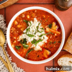 Bowl of Lasagna Soup topped with cheese mixture and parsley, ready to be served