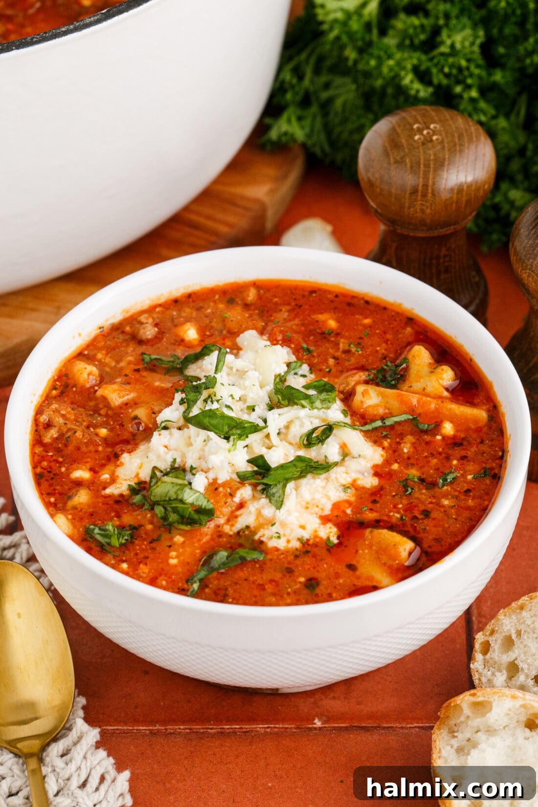 Bowl of Lasagna Soup topped with a dollop of creamy cheese mixture and fresh parsley