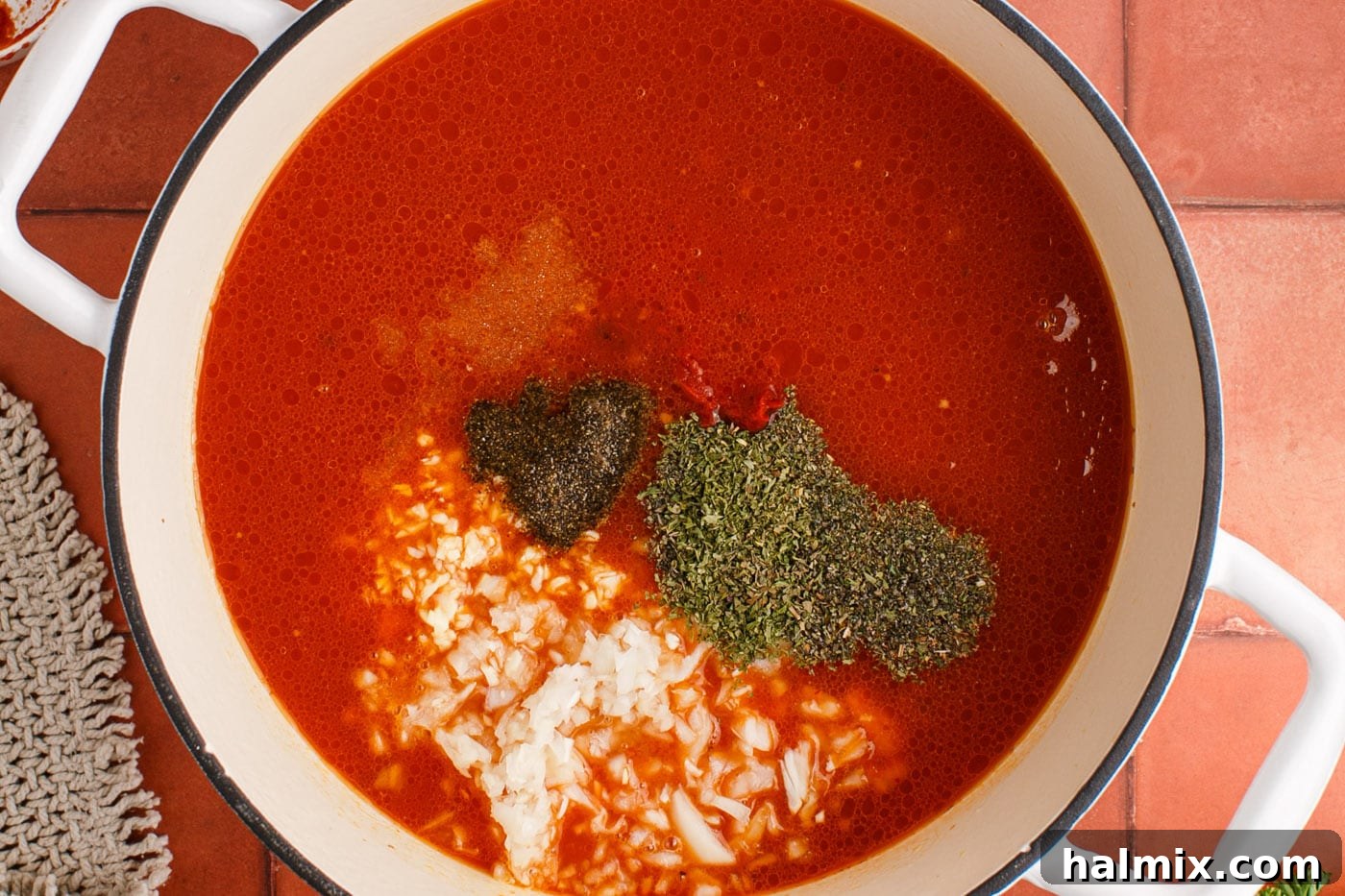 Italian herbs and seasonings, including dried parsley, oregano, and basil, added to the simmering marinara, beef, and sausage mixture