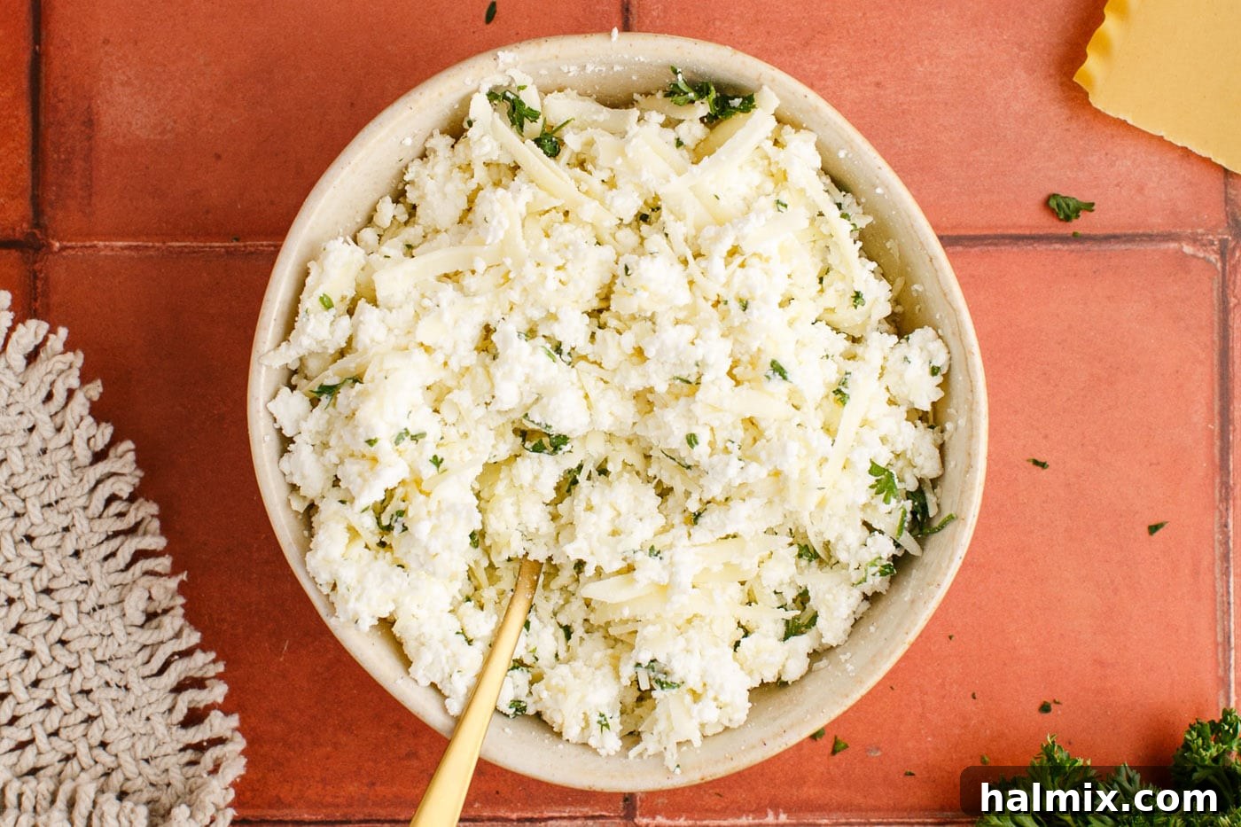 Creamy three-cheese mixture of ricotta, mozzarella, and parmesan with fresh parsley in a bowl