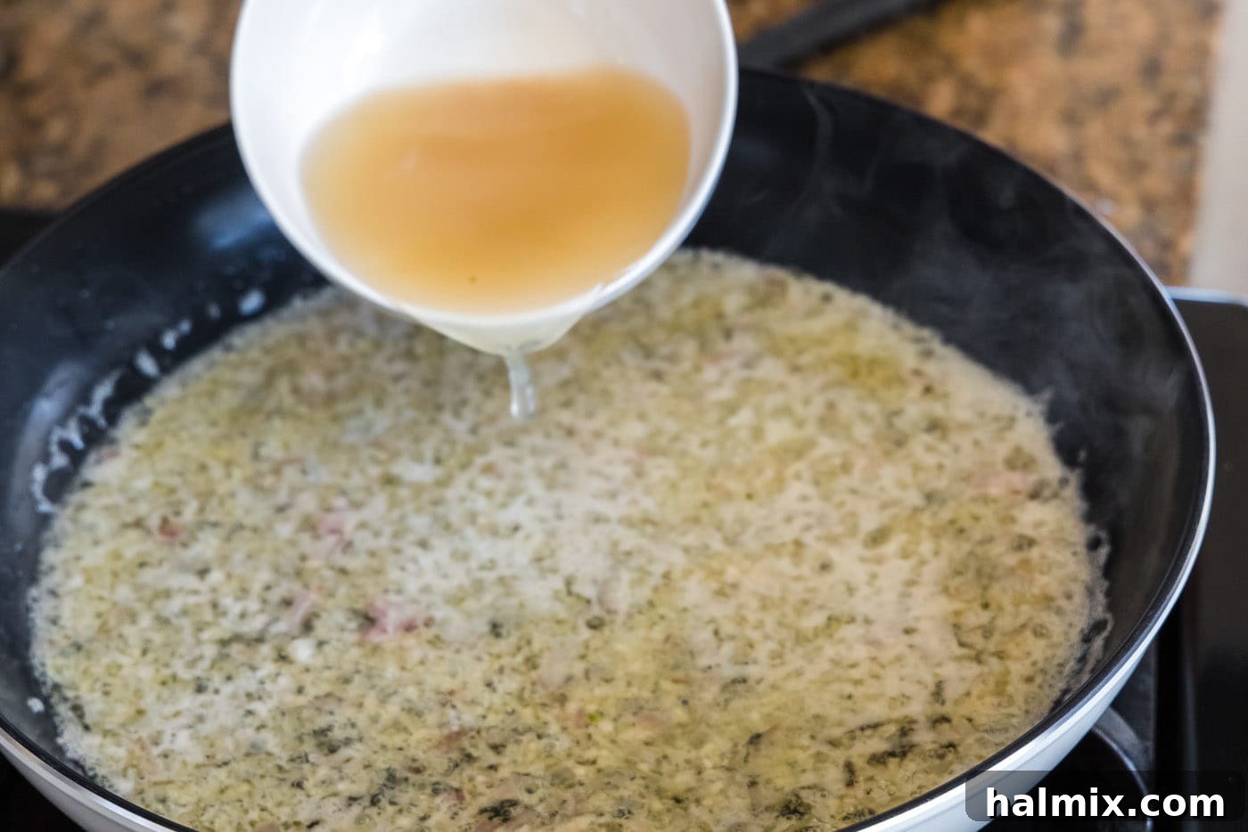 Golden Lobster Indulgence 11 pouring seafood stock into thermidor sauce