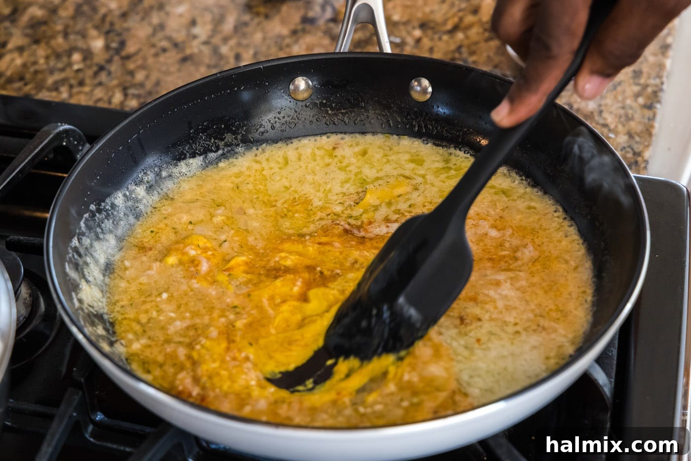 Golden Lobster Indulgence 13 mixing lobster thermidor sauce with a spatula